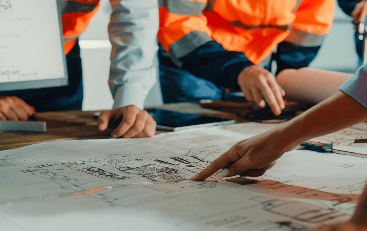 Engineers reviewing construction blueprints at table