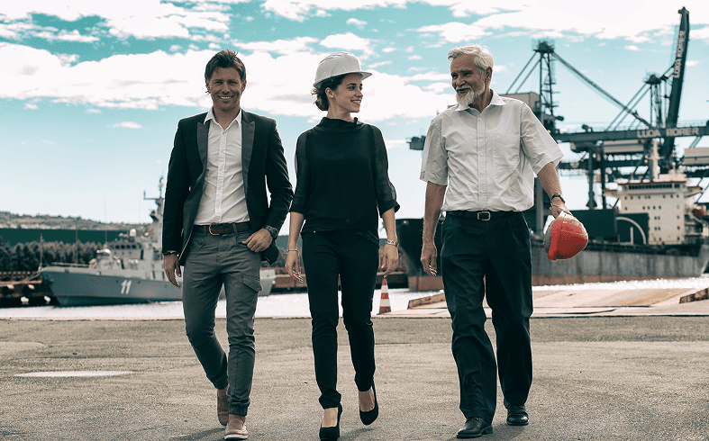 Business team walking at shipyard with cranes